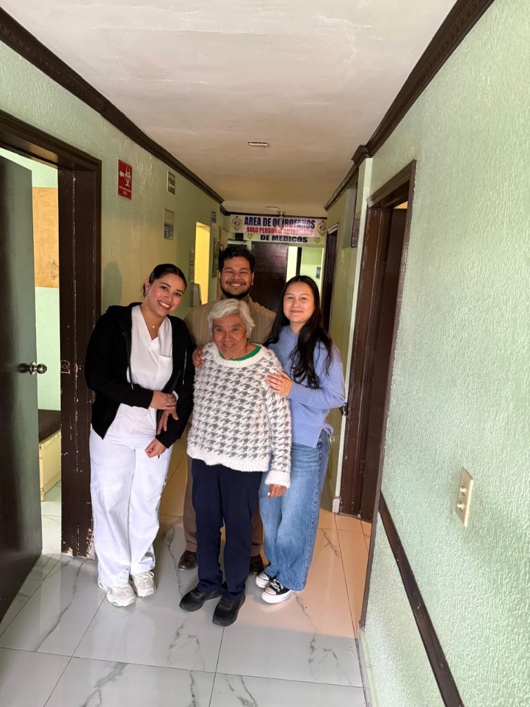 Equipo de Clínica La Mesa con una paciente en el pasillo del consultorio